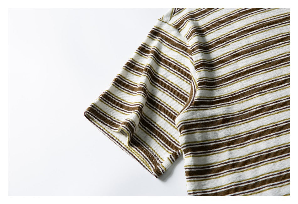 Close-up of the short sleeve and side of a cream shirt with brown, olive, and white horizontal stripes.