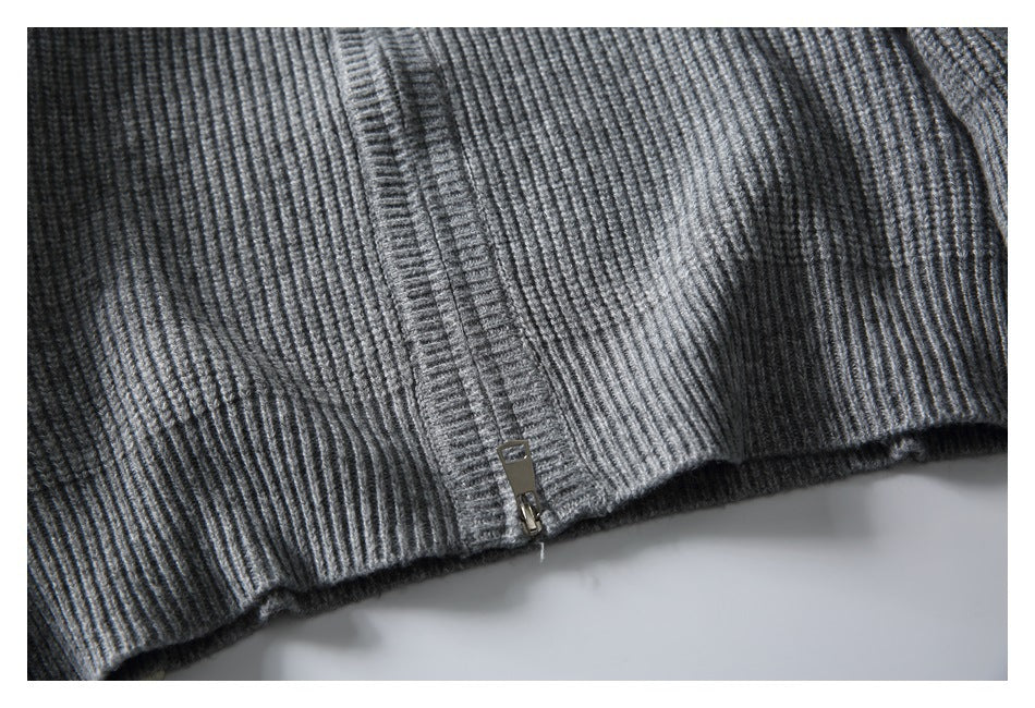 Close-up of a gray rib-knit sweater hem with a zipper at the edge.