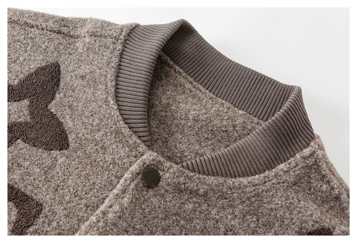 Close-up of the beige knit garment's ribbed brown collar and dark snap button.