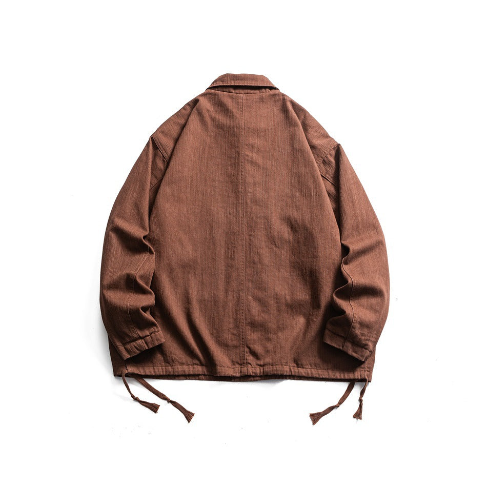 Back view of a rust-brown collared jacket with long sleeves and dangling hem ties, laid flat.