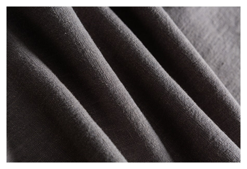 Macro view of the dark gray garment fabric draped into soft folds.