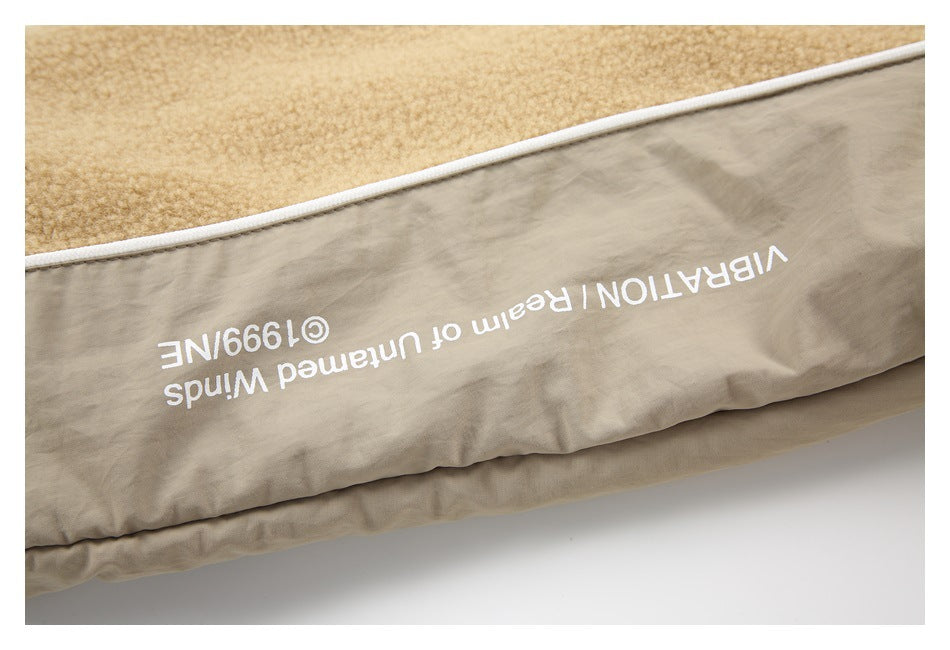 Close-up of a beige garment panel printed with upside-down white English text beside tan fleece.