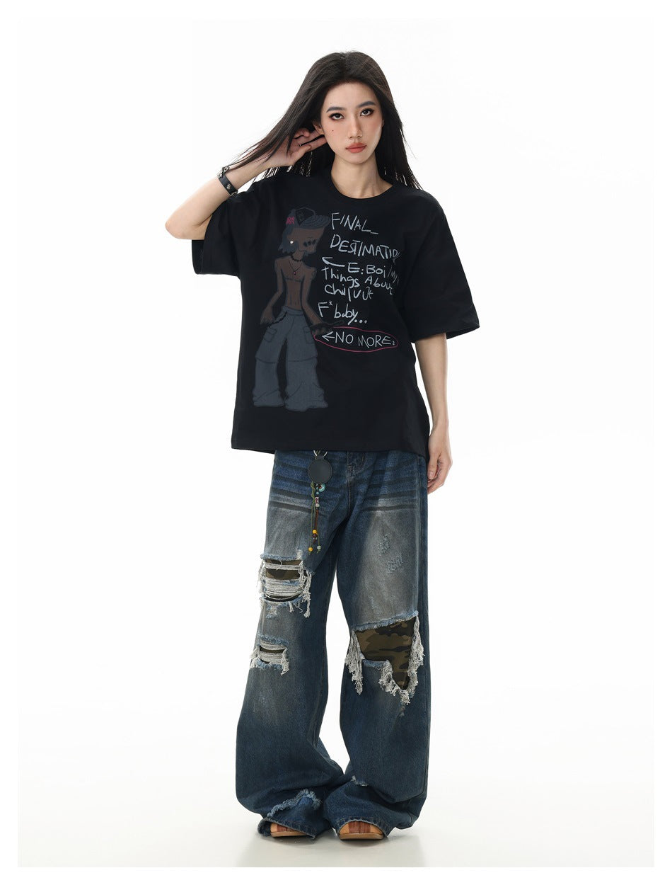 Full-length model wearing an oversized black graphic T-shirt and distressed, wide-leg blue jeans.