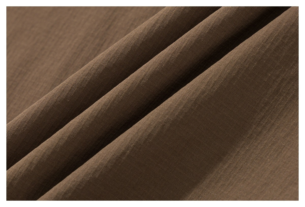 Close-up of brown fabric with a fine crosshatched texture, draped in soft folds.
