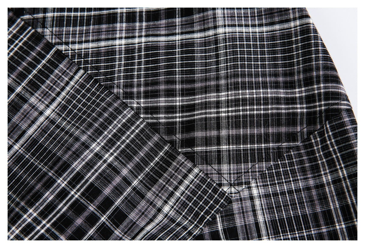 Close-up of black, white, and gray plaid fabric showing a curved stitched seam.