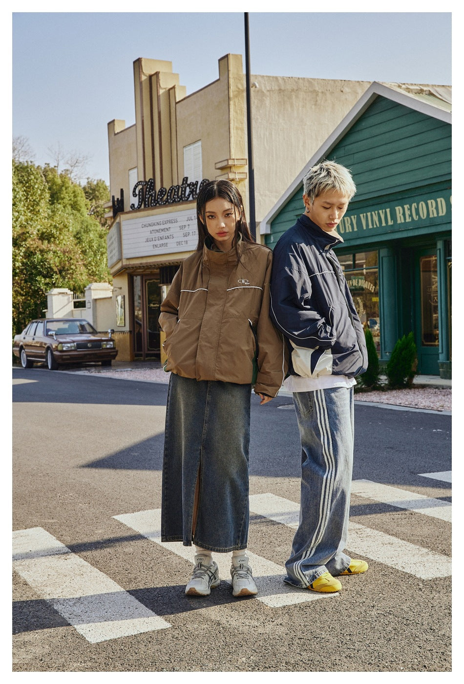 Two models wear brown and navy jackets with white piping; the navy jacket has pale side panels.