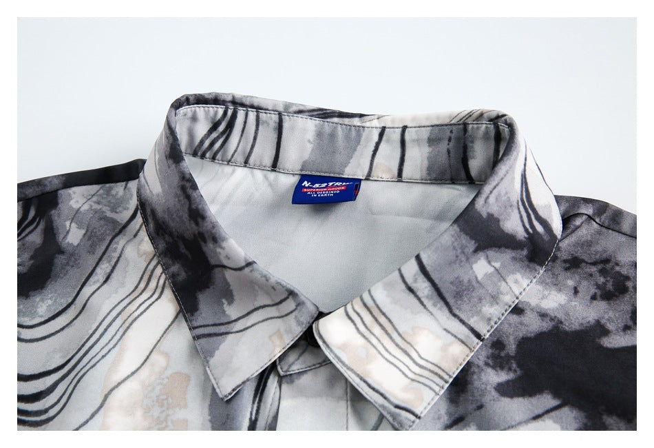 Close-up of a pointed collar on a gray, black, and cream abstract-print shirt.