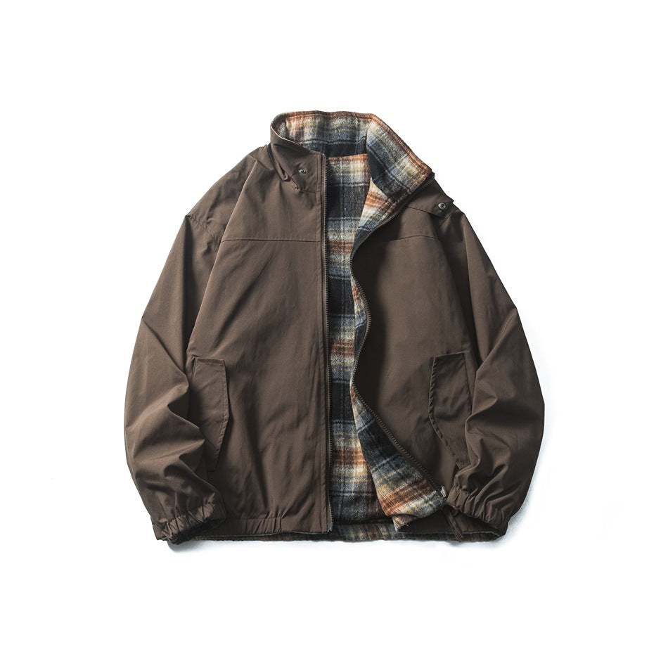 Brown reversible stand-collar zip jacket laid flat, open to show the black, orange and cream plaid inner side
