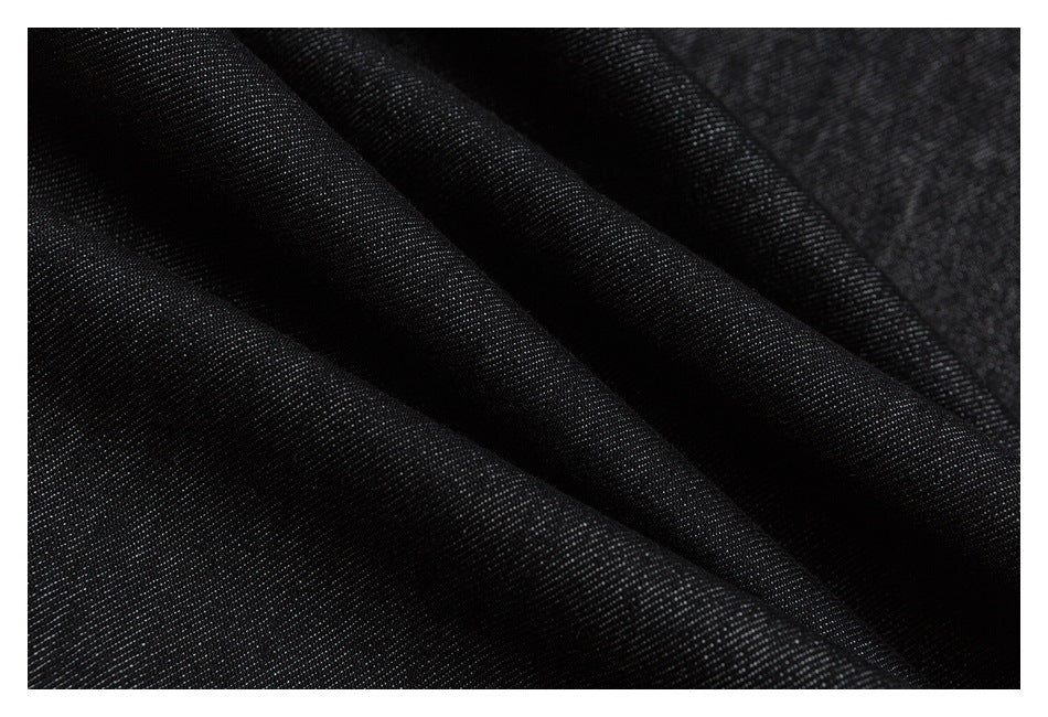 Macro view of the dark, finely textured fabric with soft folds.
