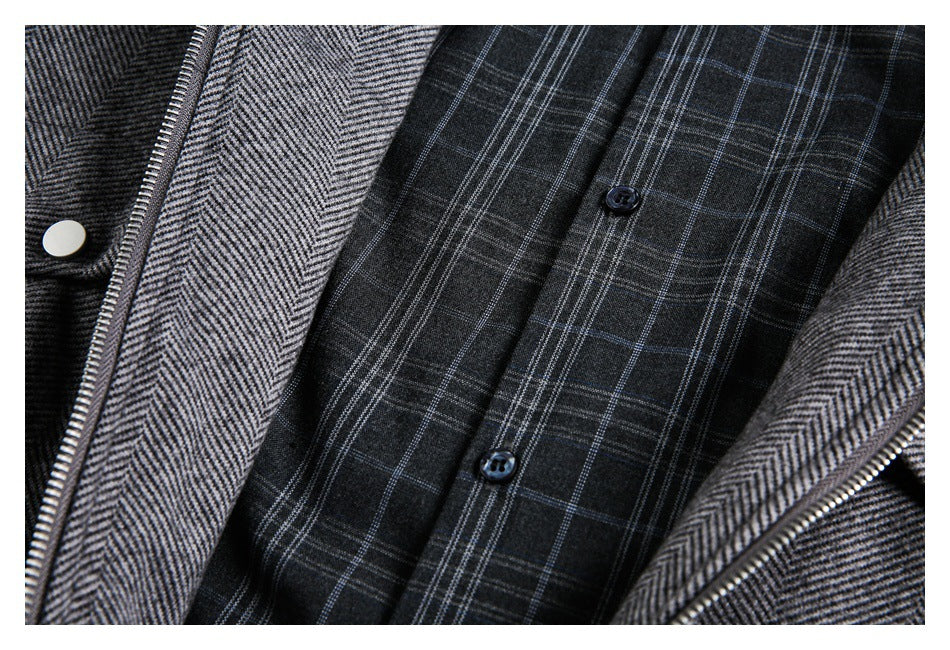 Close-up of a gray herringbone jacket opened to show dark plaid lining and buttons.