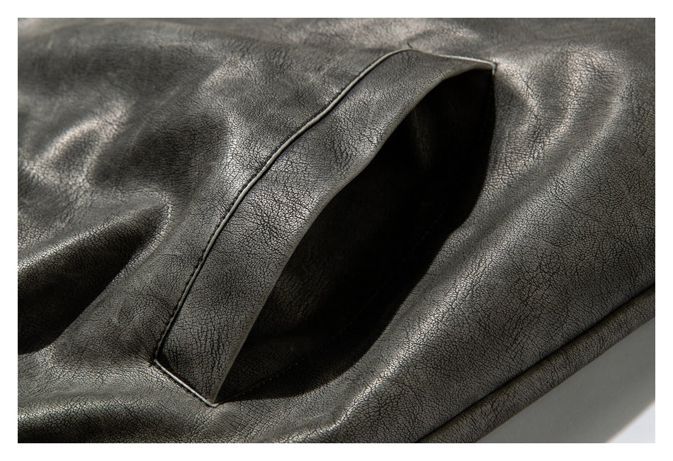 Close-up of a slanted welt pocket on the charcoal gray textured jacket.
