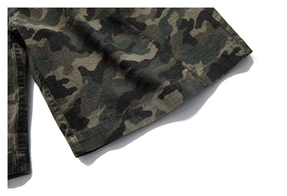 Close-up of a camouflage trouser leg hem with visible stitching.