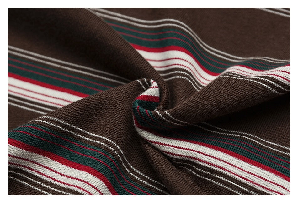 Draped close-up of brown striped knit fabric with red, green and white bands.