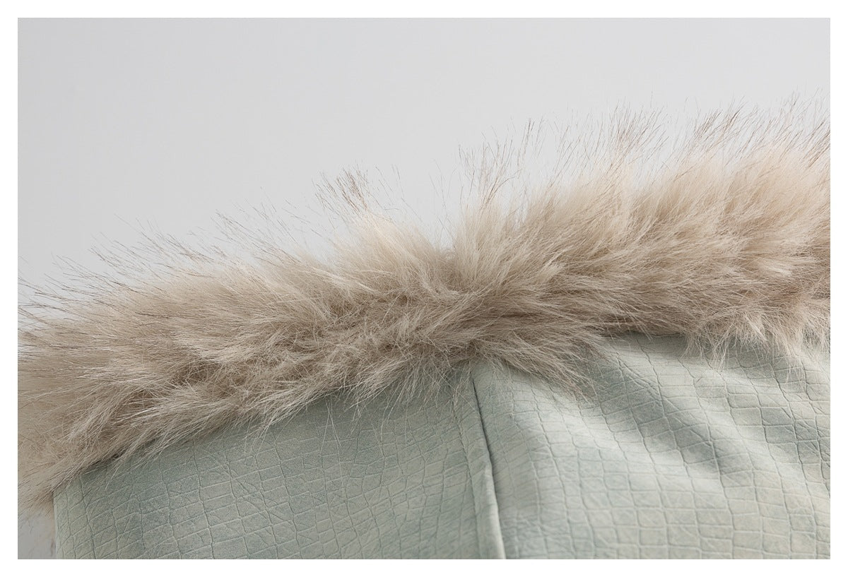 Close-up of beige faux-fur hood trim above sage-green fabric with a raised square texture.