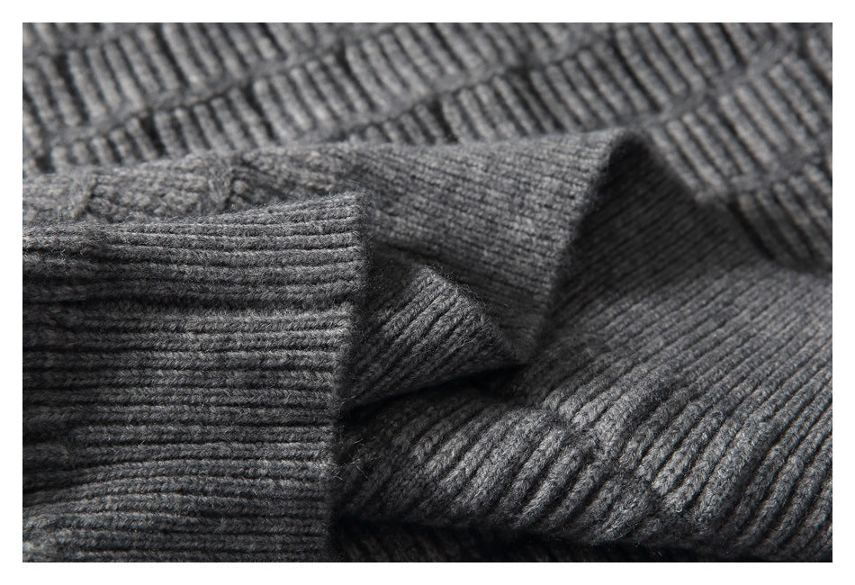 Close-up of the gray sweater's ribbed cuff and textured knit fabric.