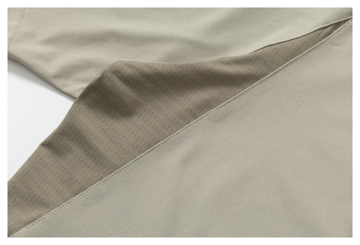 Close-up of a light taupe T-shirt seam with a patterned inner fabric panel visible.
