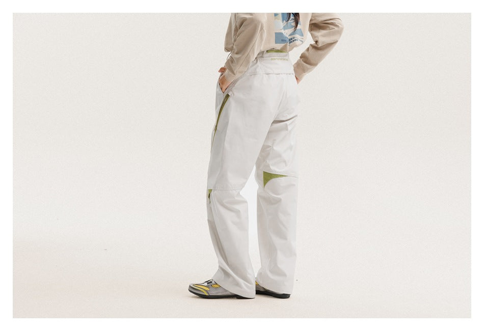 Back view of a model wearing light gray pants with olive accents at the pocket and knee.