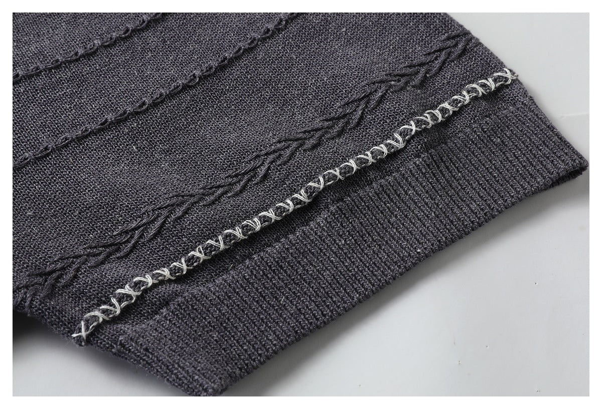 Close-up of a charcoal sweater hem with ribbed trim and a decorative light loop-stitched line.