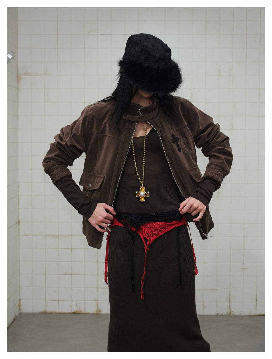Model wearing a dark brown zip-front jacket with a high collar, chest appliqué and gathered cuffs, styled with dark clothing.