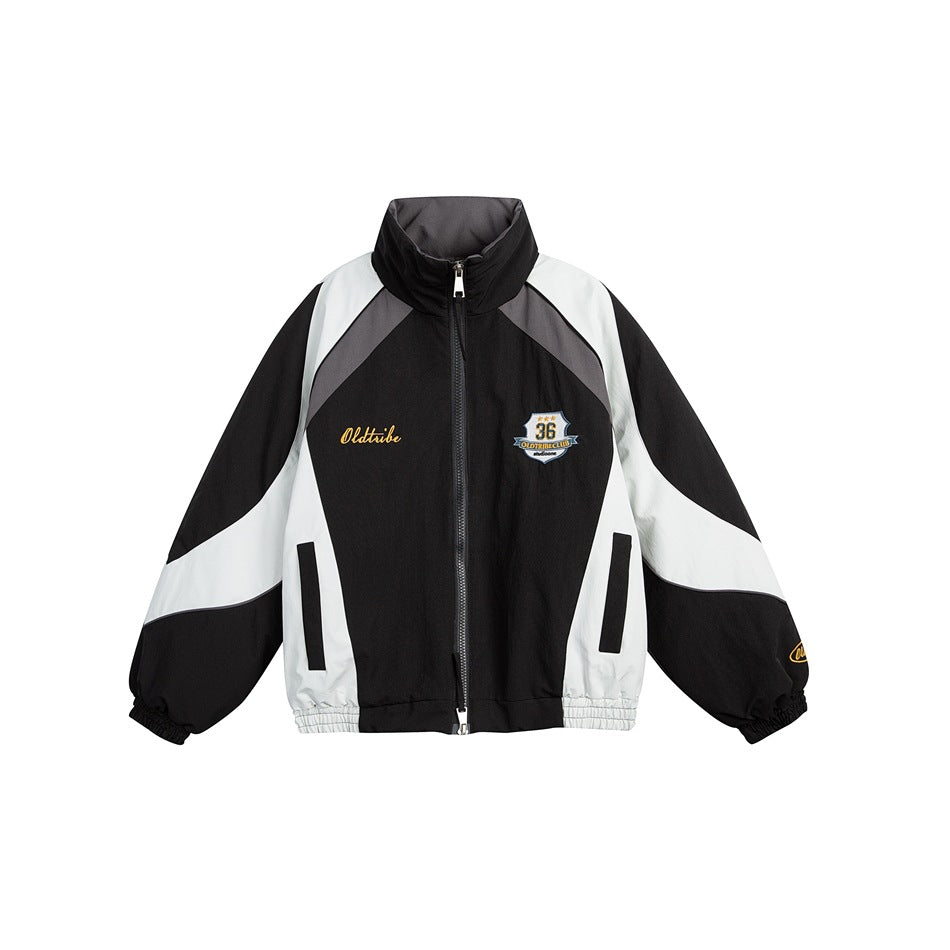 Black zip-up stand-collar jacket with light gray and dark gray color-block panels and embroidered chest badge