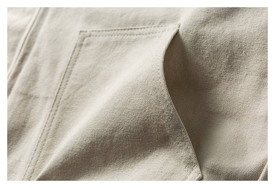 Close-up of a stitched pocket edge and seam on beige fabric.