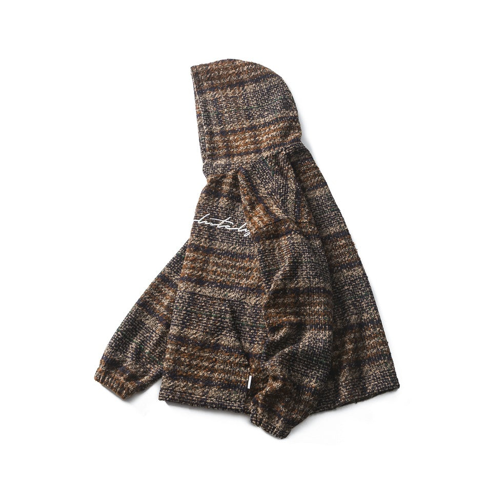 Angled side view of the plaid hooded pullover, showing its hood, sleeve, and partial chest script.