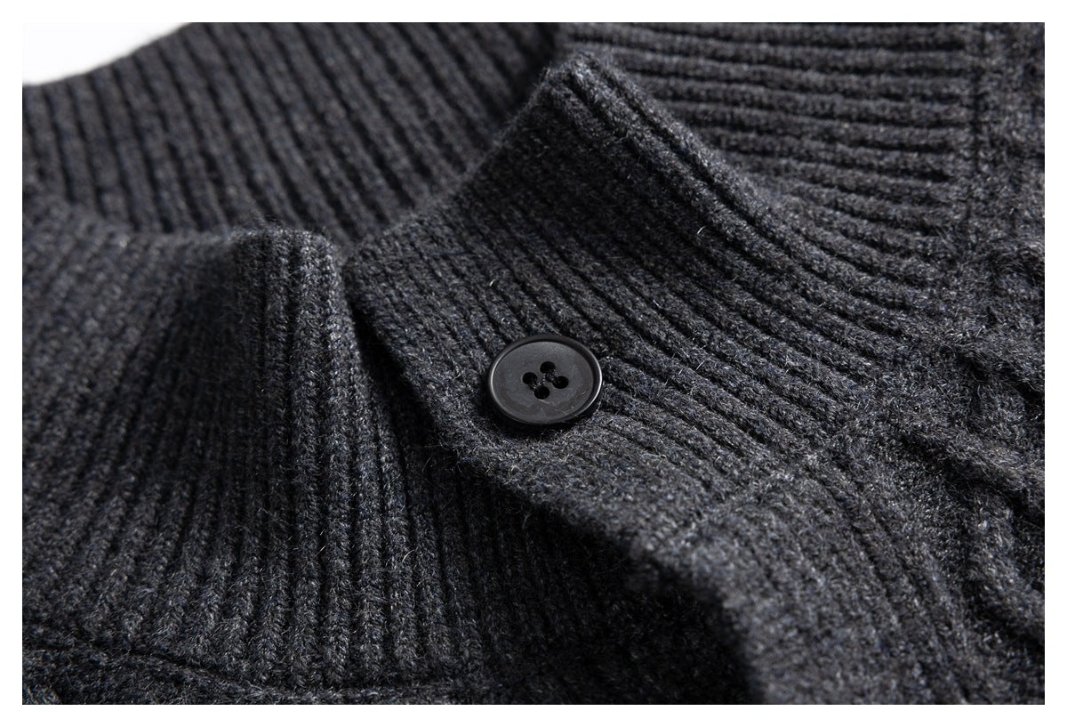 Close-up of a dark button on the ribbed collar and cable-knit fabric of a charcoal gray cardigan.