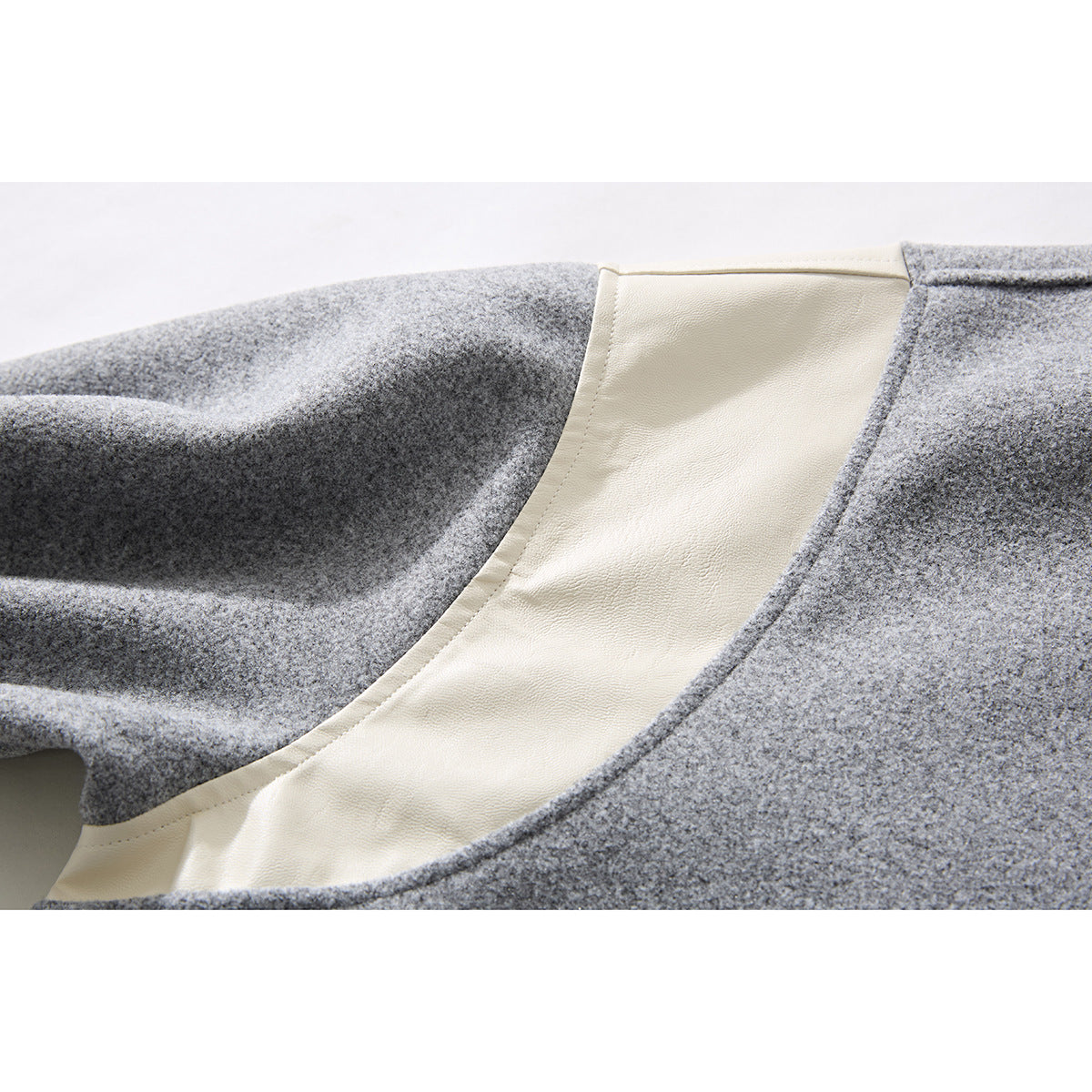 Close-up of a gray jacket interior showing a wide cream-colored lining panel.