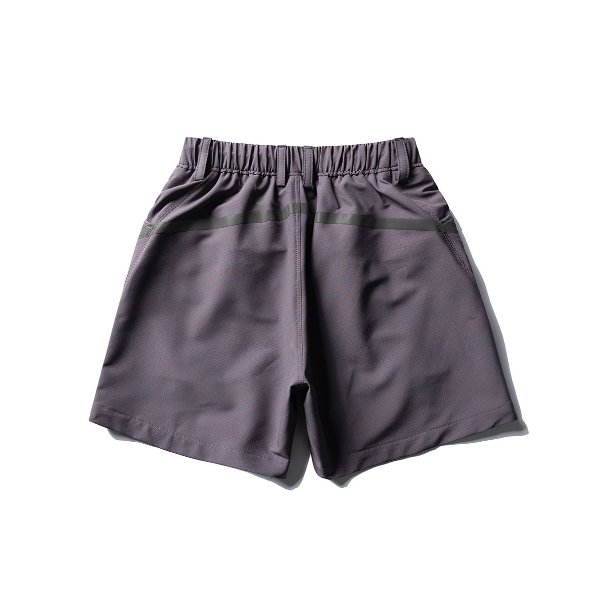 Front view of muted purple-gray shorts with an elastic waistband, belt loops, angled pockets, and a dark green stripe.