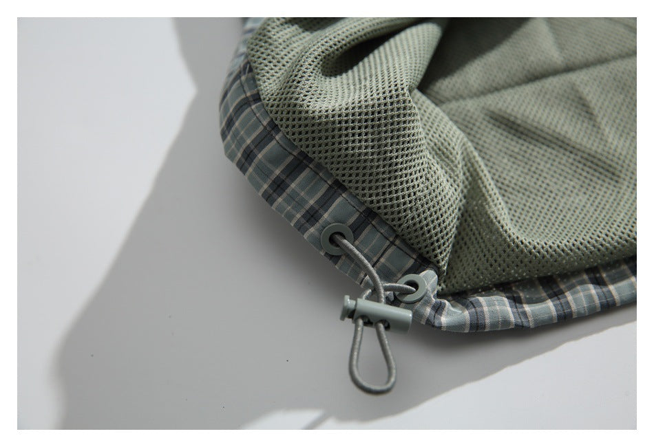 Close-up of mesh lining and an adjustable drawcord at the hem of a plaid jacket.