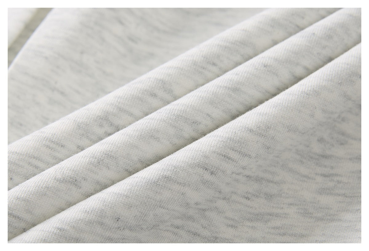Close-up of light gray heathered knit fabric arranged in soft folds.