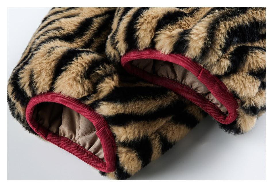 Close-up of tan-and-black tiger-striped faux fur with burgundy binding around two openings and beige lining.