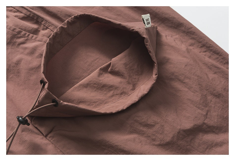 Inside view of a mauve-brown garment opening with a black drawcord and toggle.