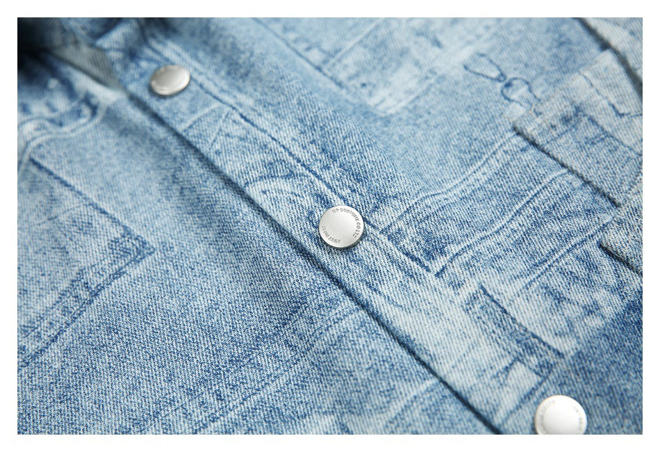 Close-up of silver snap buttons and distressed graphic print on light blue denim.