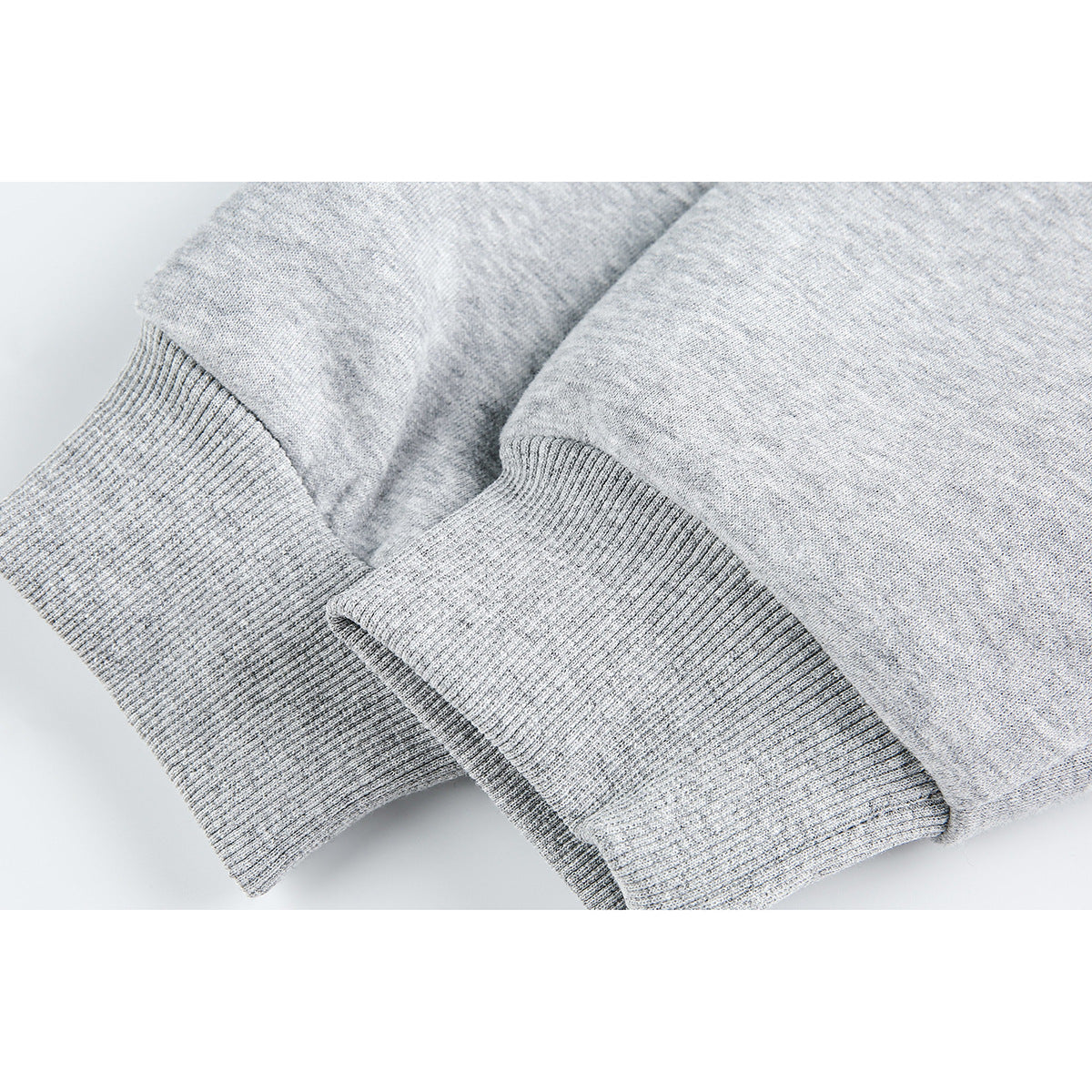 Close-up of the light gray jacket's ribbed cuffs and sleeve fabric.