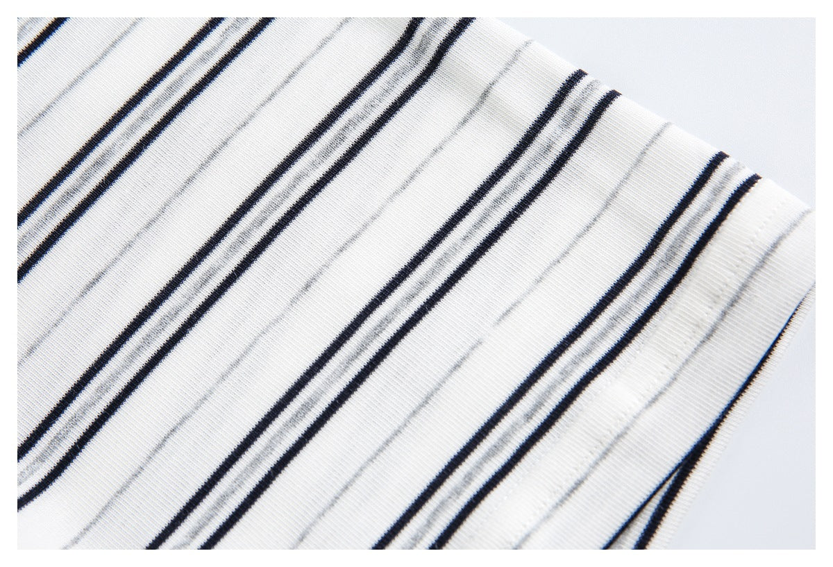 Close-up of white knit fabric with thin black and gray stripes.