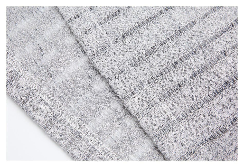 Close-up of a gray garment seam and openwork stripe construction.