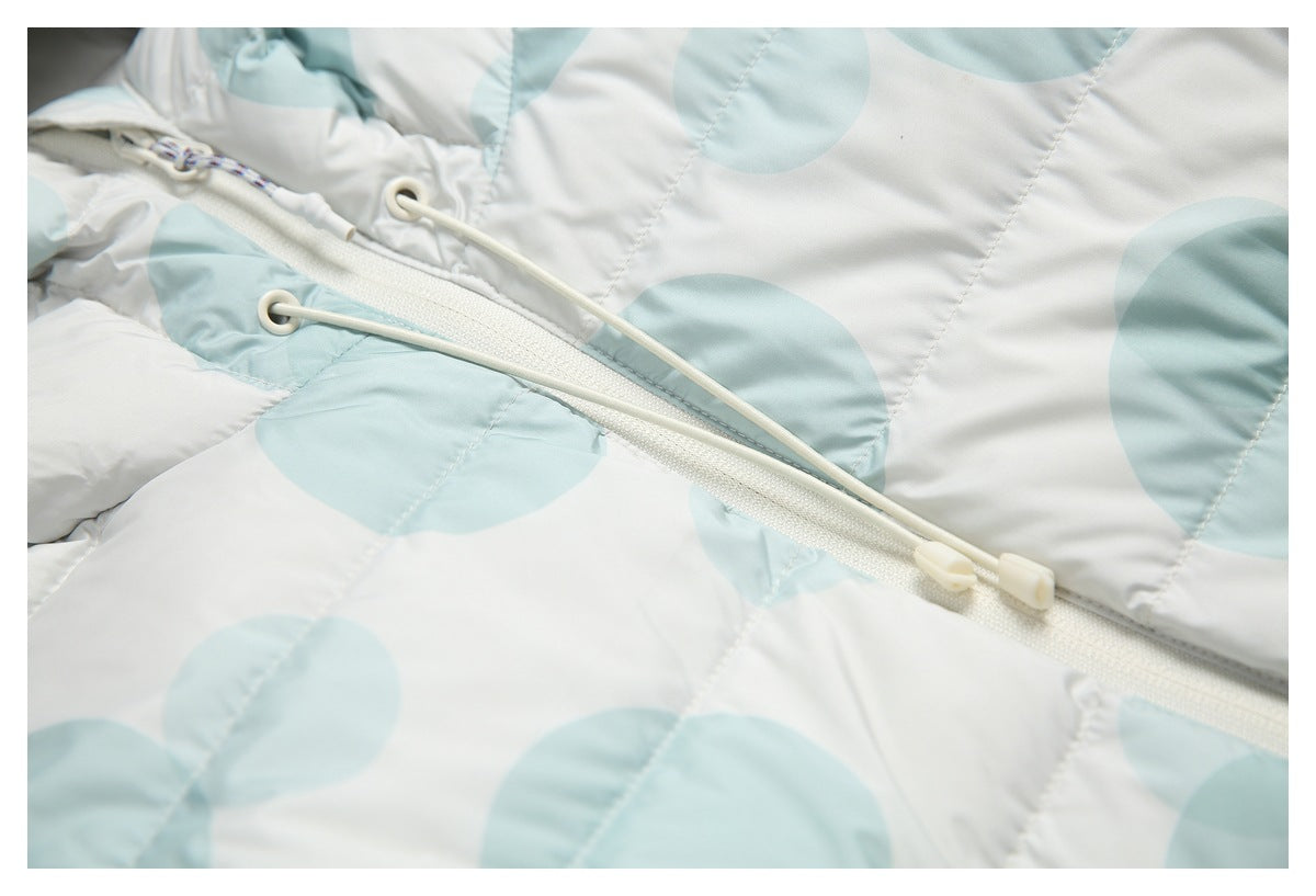 Close-up of the jacket's white front zipper and drawcords over its pale aqua circle-print quilting.