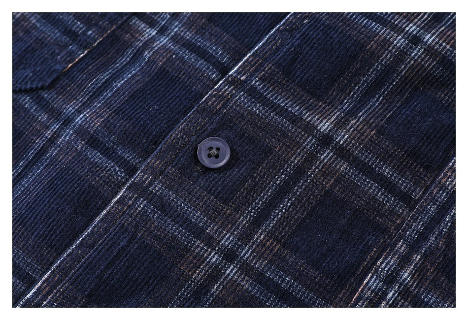 Close-up of a dark four-hole button against navy plaid shirt fabric.