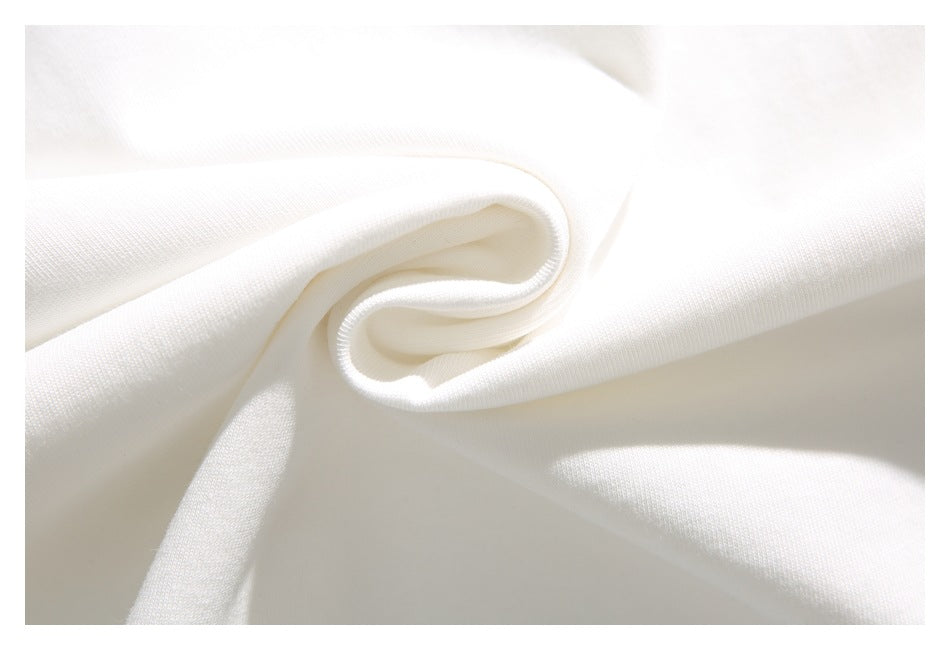 Close-up of white fabric gathered into a soft fold, showing its fine surface texture.