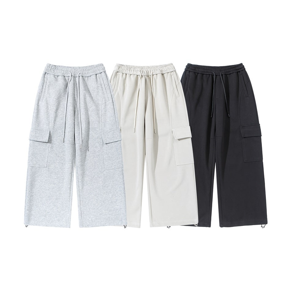 Three pairs of wide-leg cargo pants shown from the front in light gray, ivory, and black.