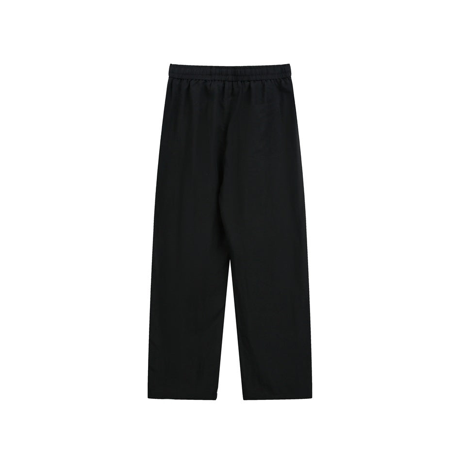 Black straight-leg pants shown flat from the front, with an elastic waistband and a subtle side pocket.