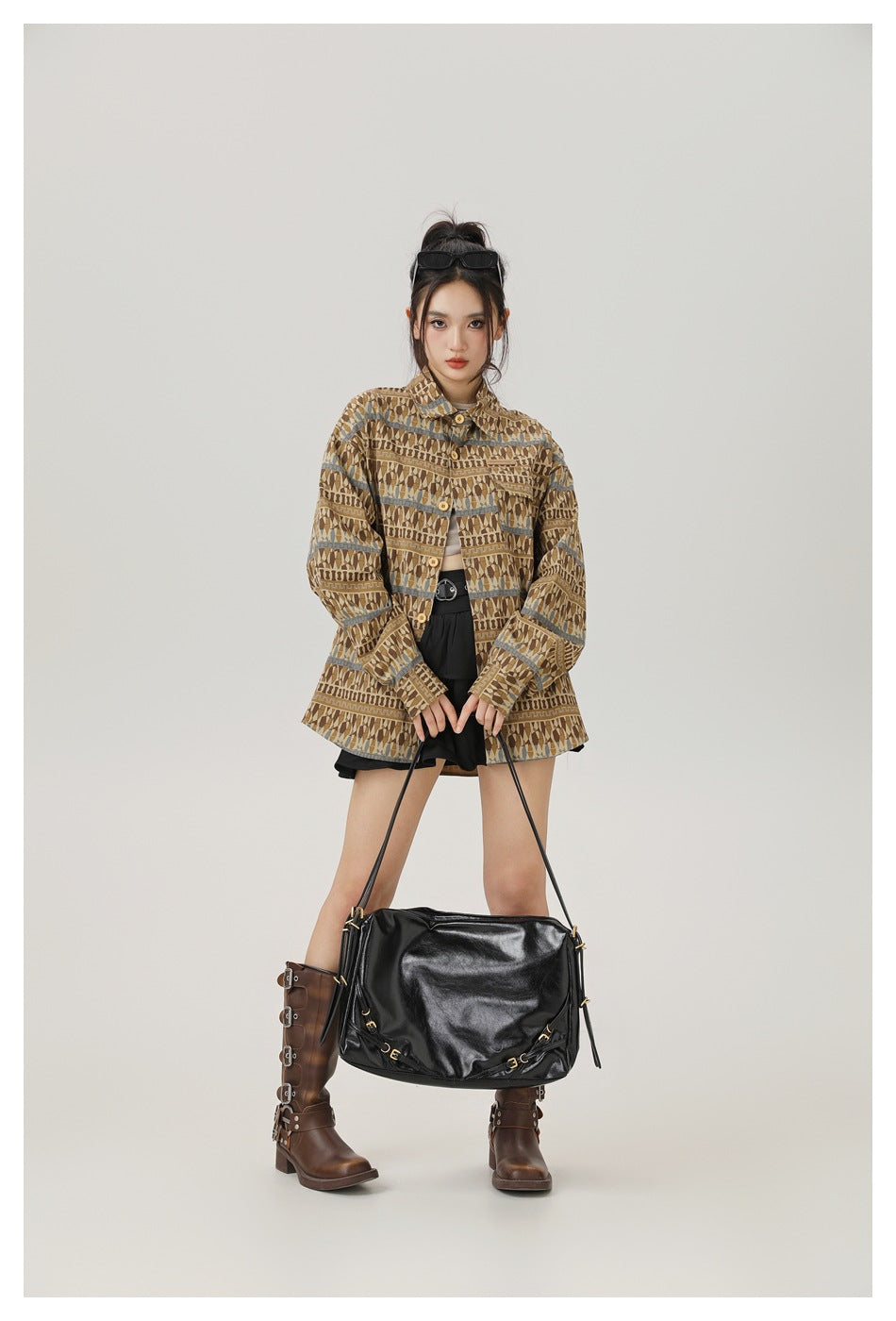 Full-length front view of a model wearing a brown geometric-pattern jacket with blue-gray stripe accents.