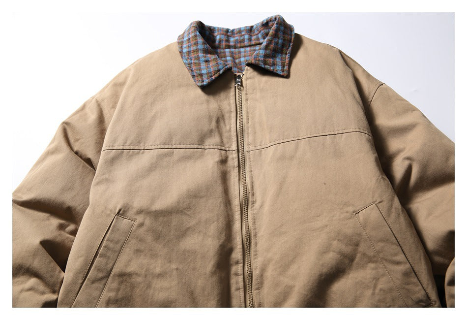 Front view of a tan zip-up jacket with a blue, red, and brown plaid collar.