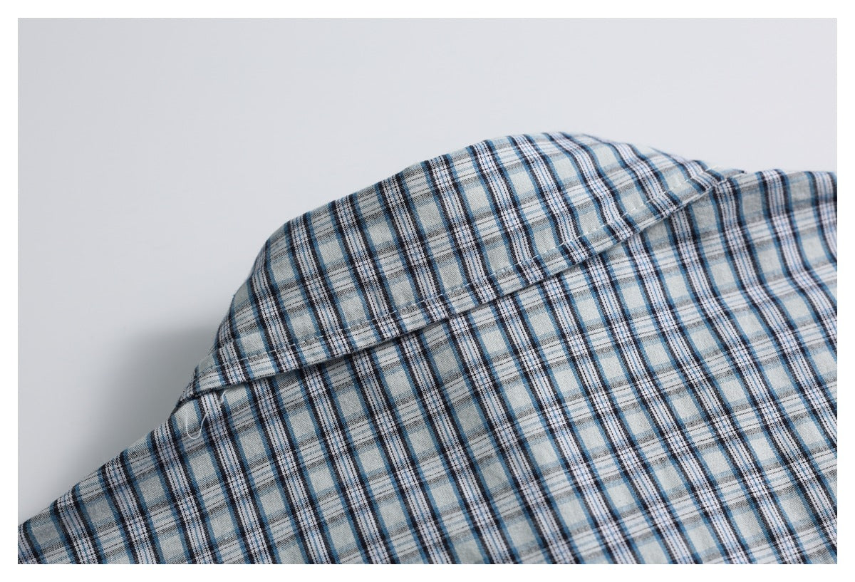 Close-up of the blue plaid shirt collar and shoulder seam.