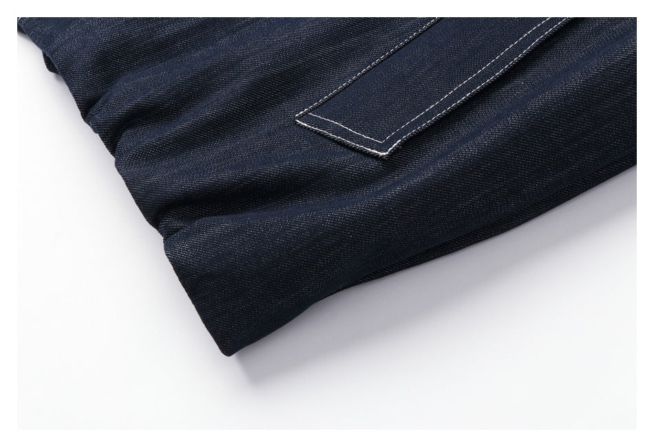 Close-up of a stitched rectangular denim detail near a folded edge.