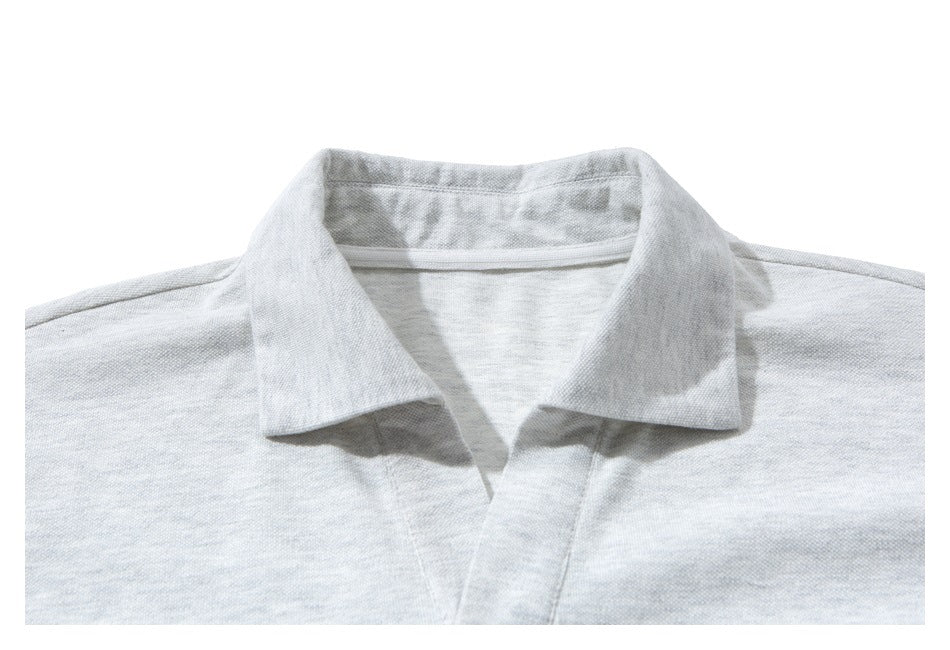 Close-up of the light gray shirt's pointed collar and neckline.