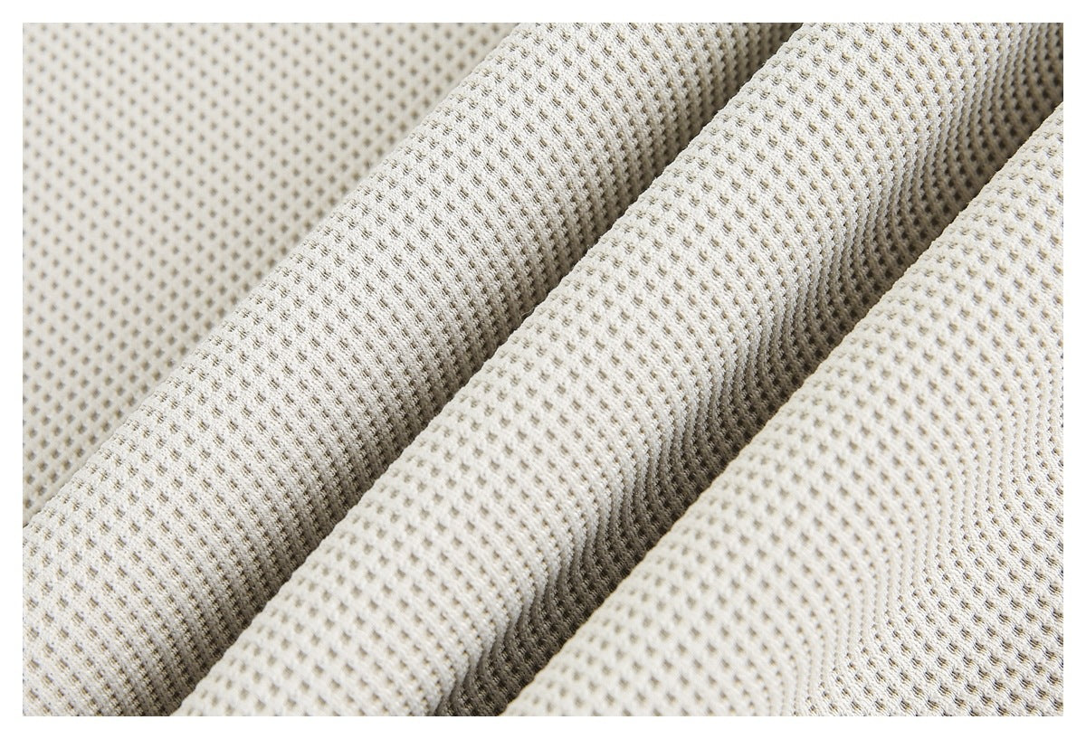 Close-up of off-white textured fabric arranged in soft folds, showing its repeating pattern.