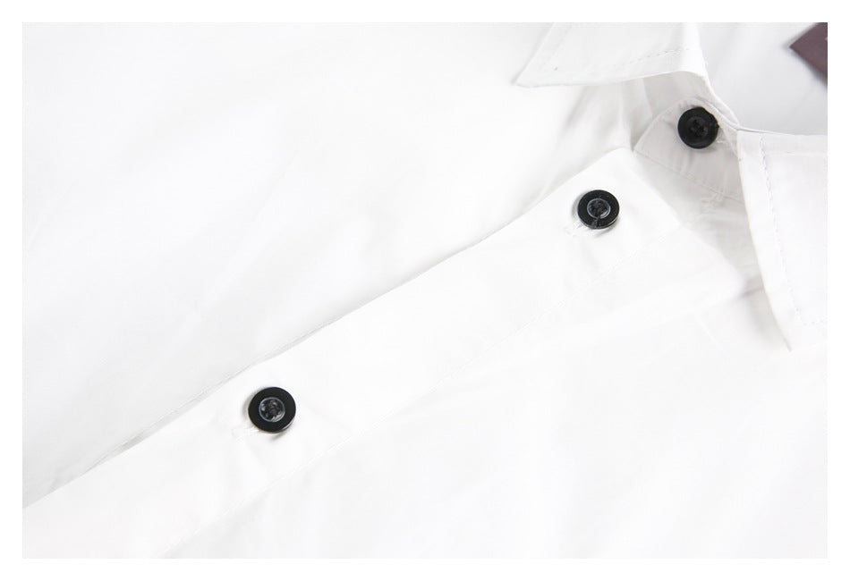 Close-up of the white shirt's front placket with three black buttons.