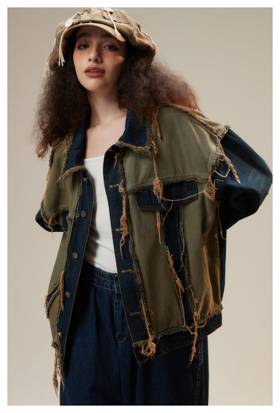 Model wearing an olive and dark denim patchwork jacket with frayed seams, shown from the front.